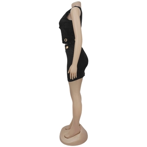 Détail de l'ensemble noir cintré avec œillets dorés à la taille et au décolleté
