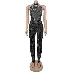 Dettaglio di un'elegante tuta nera slim fit con strass e raffinato design a lupetto