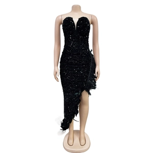 Détail des paillettes noires scintillantes et bordure en plumes sur l'ourlet asymétrique