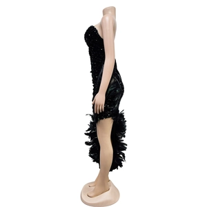 Détail de la robe bustier à paillettes avec ourlet asymétrique et bordure en plumes noires