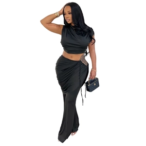 Detail of black two-piece set featuring a sleeveless crop top and high waist draped pants