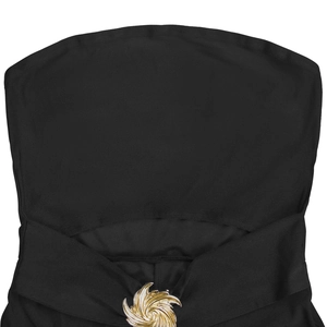 Close-up of black elastic knit fabric with a golden swirl metal buckle detail
