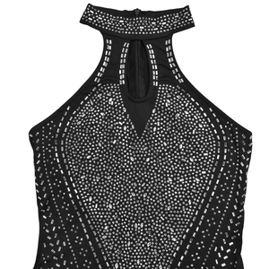 Dettaglio di un'elegante tuta nera con strass argentati e decorazioni di borchie metalliche
