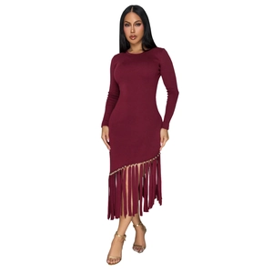 Dettaglio dell'abito in maglia bordeaux con frange asimmetriche e accenti di perline dorate
