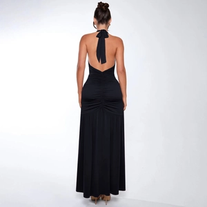 Detail of elegant backless halter dress showing ruched waist and pleated skirt texture
