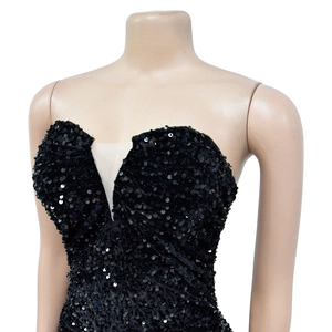 Détail d'une robe noire à paillettes avec col en V profond et empiècement en résille nude