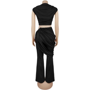 Detail view of the back showing asymmetrical draped fabric on black high-waisted flared pants