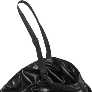 Close-up of adjustable straps and shiny faux leather texture on black party dress