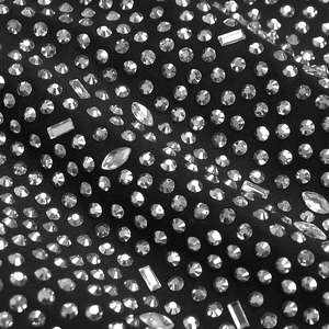 Macro di tessuto nero decorato con strass di varie forme per abiti da sera di alta classe
