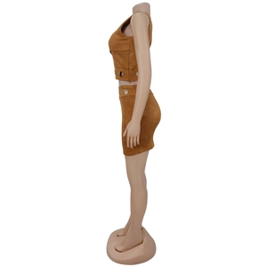 Détails d'un ensemble deux pièces en daim caramel avec œillets métalliques sur haut et jupe