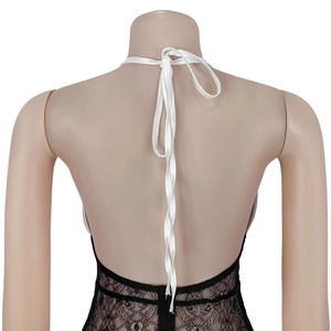 Detail of sexy black lace bodysuit with white satin halter neck tie and open back design