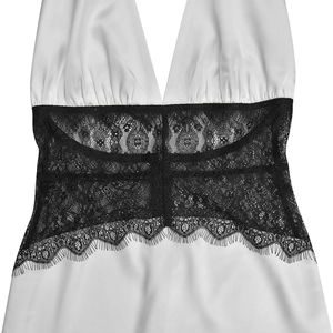 Detailed close-up of white satin fabric with intricate black eyelash lace patchwork detail