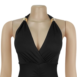 Detail of elegant black halter top with deep V-neck and decorative gold metal rings