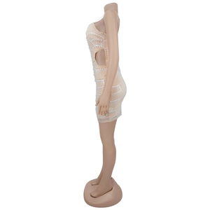 Detail of light beige mini dress featuring white pearls and side cutout on mannequin