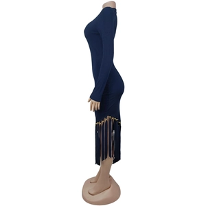 Dettaglio dell'abito blu a costine con orlo a frange e perline dorate decorative