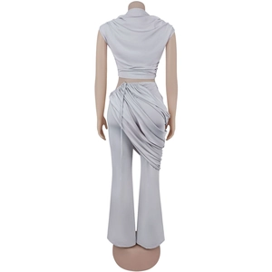 Detail view of the elegant asymmetric draping and layered ruffles on high-waist grey pants