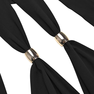 Close-up of elegant black fabric with decorative gold oval buckles on the dress