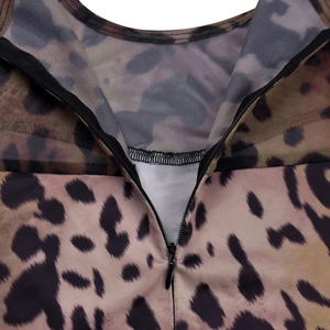 Detailed view of the invisible back zipper and leopard print mesh fabric on the bodysuit