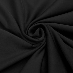 Close-up of elegant black knitted fabric with fine mesh texture and soft draping folds