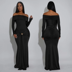 Détail de la robe maxi noire épaules dénudées avec fronçages et boucle dorée à la taille