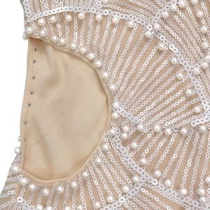 Detail of sequins and pearls on mesh fabric with metal snap closure of a party dress
