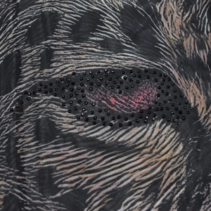 Detail of sheer black mesh fabric featuring realistic animal print and black rhinestones