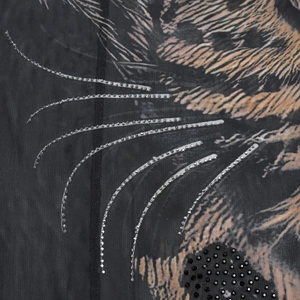 Detail of mesh fabric with feline print, silver sequins, and black rhinestone embellishments