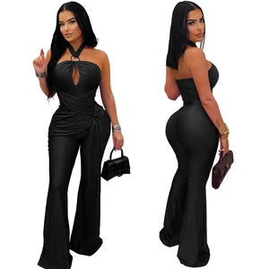Detail of black halter jumpsuit showing cross-wrap bodice and flared wide-leg pants