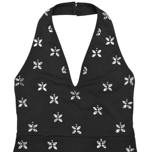 Dettaglio di un elegante abito nero con scollo all'americana e fiori di strass lucidi
