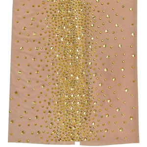 Détail macro de la robe en tulle nude avec des strass dorés en motif dégradé