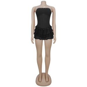 Detail of black strapless corset dress with tiered ruffle hem and metal accents
