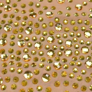 Gros plan de strass jaunes sur le tissu en maille transparente de la robe moulante
