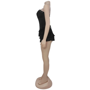 Side view of black strapless mini dress with ruffle hem and silver ring detail
