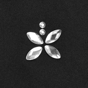 Dettaglio di strass a marquise e rotondi su elegante tessuto nero di un vestito