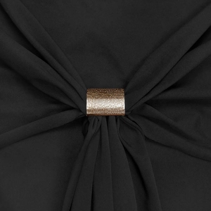 Détail d'une boucle rectangulaire dorée texturée sur le tissu plissé d'une robe noire chic