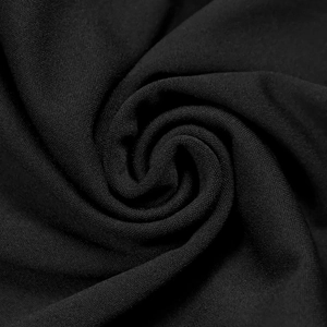 Dettaglio macro della consistenza morbida e del drappeggio fluido del tessuto nero elegante