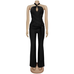Detail of black halter neck jumpsuit featuring chest cutout and waist buckle detail