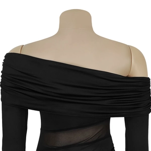 Detail of the sheer mesh waist cutout on a black off-shoulder long sleeve dress