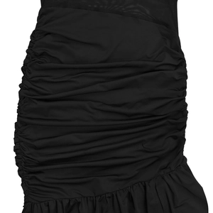 Macro detail of black dress showing mesh patchwork, pleated fabric, and ruffled hem