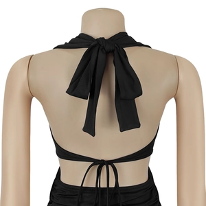 Detail eines schwarzen Neckholder-Kleids mit rückenfreiem Design und eleganter Schleife