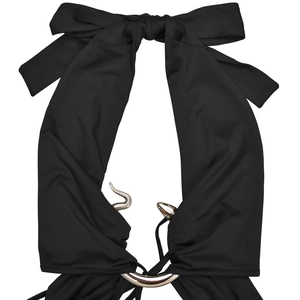 Detail eines schwarzen Neckholder-Kleides mit großer Schleife und silbernem Schlangenring