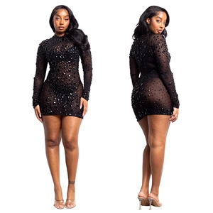 Dettaglio mini abito in mesh con strass neri scintillanti e maniche lunghe trasparenti