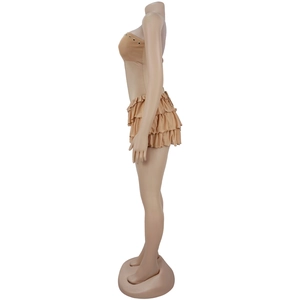 Close-up of tiered ruffle mini skirt and tube top set with metal grommet details