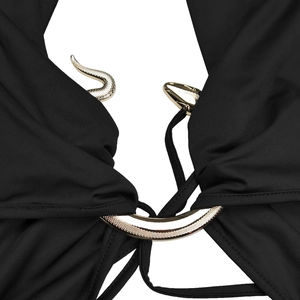 Detail einer goldenen Schlange aus Metall an einem eleganten schwarzen Kleidoberteil