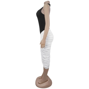 Detail view of contrast black halter top and white ruched skirt on a dress mannequin