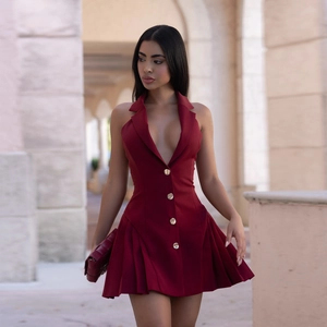 Detail of wine red halter mini dress with gold buttons and pleated hem outdoor