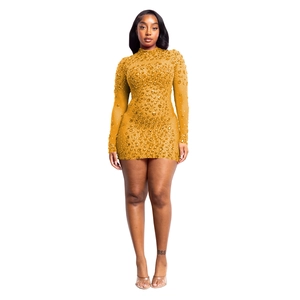 Dettaglio di mini abito in mesh dorato con strass scintillanti e collo alto