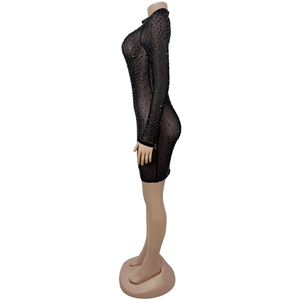 Dettaglio dell'abito in mesh nero con strass e maniche lunghe per occasioni speciali