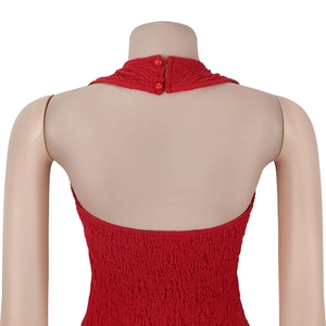 Dettaglio di un top rosso con scollo all'americana e tessuto a punto smock con bottoni