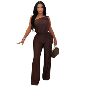 Detail of dark brown one-shoulder jumpsuit with pleated waist and wide-leg cut